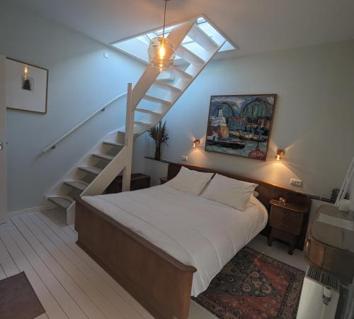 ein Schlafzimmer mit einem Bett und einer Treppe in der Unterkunft Het Pakhuis Haarlem in Haarlem