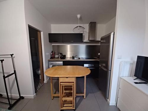 een keuken met een houten tafel en een koelkast bij Studio Villejuif in Villejuif