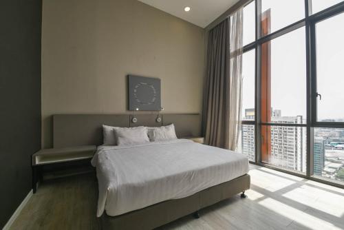 Damansara Perdana的住宿－PlayStaytion Damansara by RBNB，一间卧室设有一张床和一个大窗户