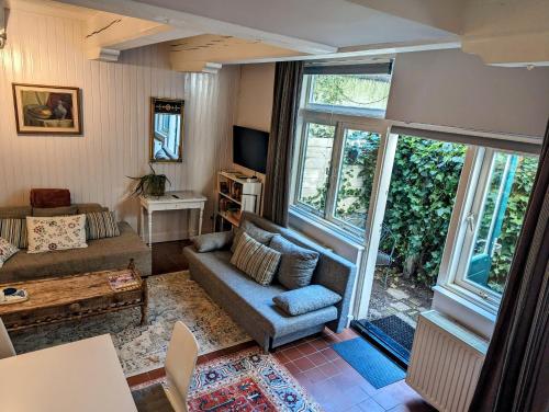 a living room with a couch and windows at Het Pakhuis Haarlem in Haarlem
