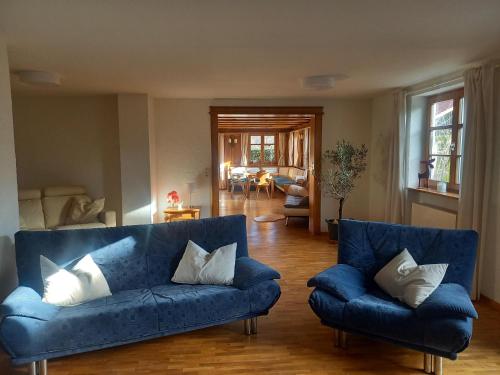 un soggiorno con divano blu e cuscini bianchi di Ferienwohnung am Stießberg a Oberstaufen