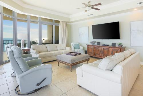 ein Wohnzimmer mit weißen Möbeln und einem Flachbild-TV in der Unterkunft Phoenix West 609 condo in Orange Beach