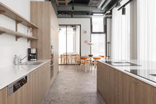 a kitchen with wooden cabinets and a dining room at Noli Otaniemi in Espoo