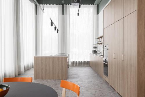 a kitchen with wooden cabinets and a table and chairs at Noli Otaniemi in Espoo