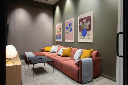a living room with a couch and paintings on the wall at Noli Otaniemi in Espoo