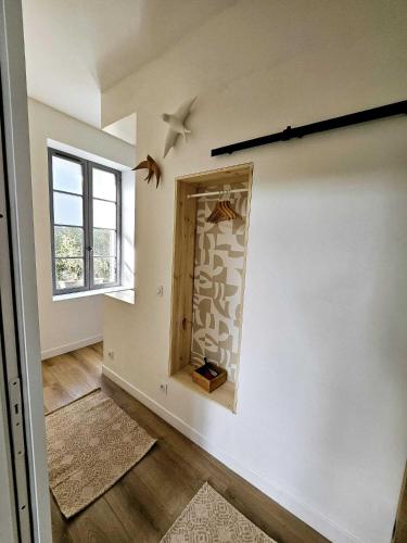 a room with a wall with a mirror and a window at La Maison Grivolas Appartements et Maison d'hôtes in Avignon