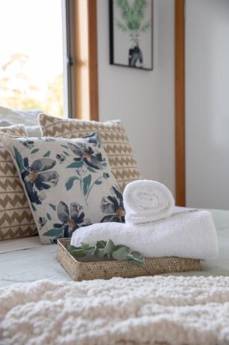 a pile of towels on a bed with a pillow at Nature & Relax House, Panoramic sea view, Free parking 37 in Hobart