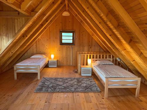 a bedroom with two beds in a wooden attic at Vikendica Ivana in Livno