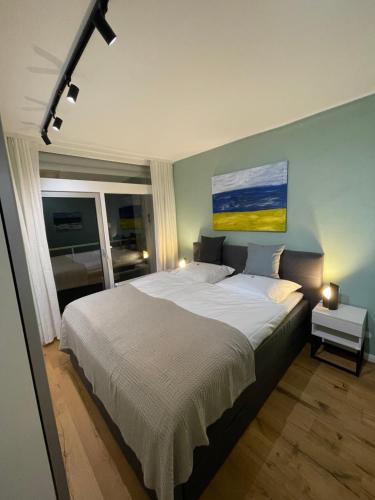 una camera da letto con un grande letto e un dipinto sul muro di Apartment Beletage Bad Harzburg a Bad Harzburg