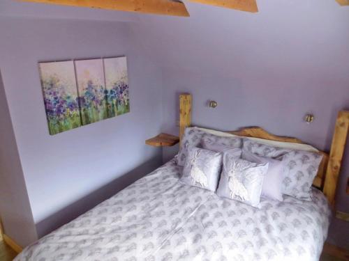una camera da letto con un letto e un quadro sul muro di Sycamore Cottage a Boat of Garten