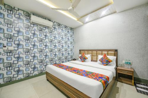 a bedroom with a large bed and a wall with patterns at FabHotel Ess Pee Grand in Mohali