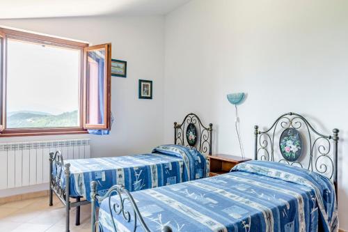two beds in a room with a window at La Panoramica Da Stroppa in Acqualagna