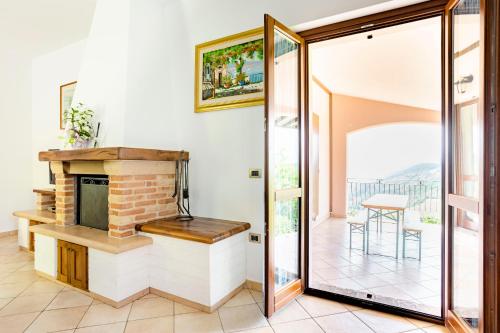 a living room with a fireplace and a glass door at La Panoramica Da Stroppa in Acqualagna
