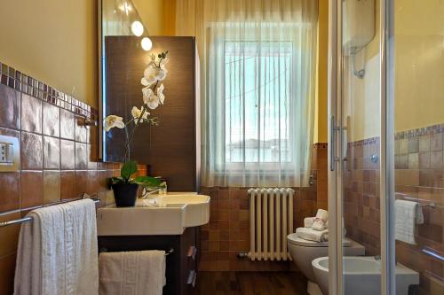 a bathroom with a sink and a toilet and a mirror at 200mt dal mare by WeHostYou Parcheggio Wifi Clima Balcone Bbq in Fermo