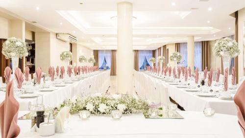 a banquet hall with white tables and pink chairs at Hotel Sylwia in Sośnicowice