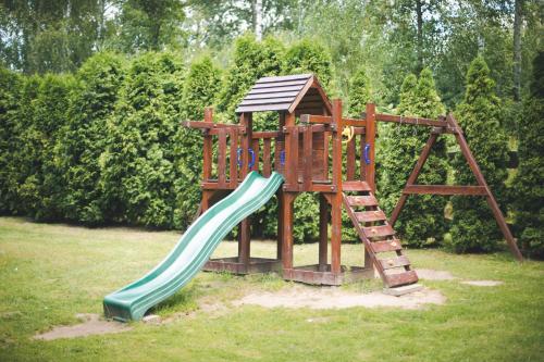 a wooden playground with a slide and a ladder at Hotel Sylwia in Sośnicowice