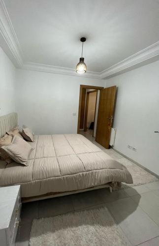 a bedroom with a large bed in a room at Appartement de la joie in El Aouina
