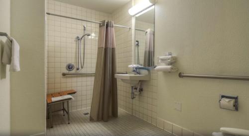 a bathroom with a shower and a sink and a shower at Motel 6-Santa Ana, CA in Santa Ana