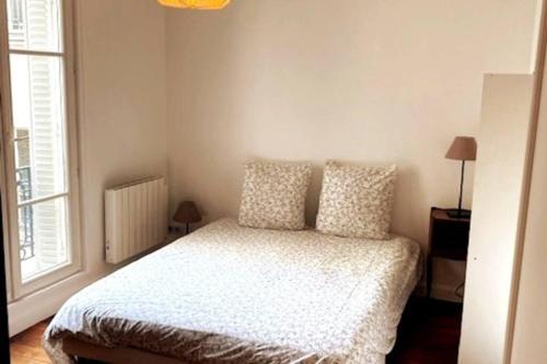 - une chambre avec un lit avec deux oreillers et une fenêtre dans l'établissement Plein cœur quartier Montorgueil, à Paris