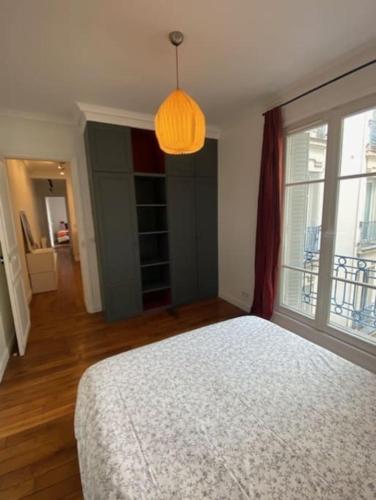 - une chambre avec un lit et une grande fenêtre dans l'établissement Plein cœur quartier Montorgueil, à Paris