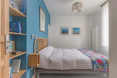 瓦訥的住宿－Superbe Villa avec Piscine Couverte au Port de Vannes，一间卧室设有一张床和蓝色的墙壁