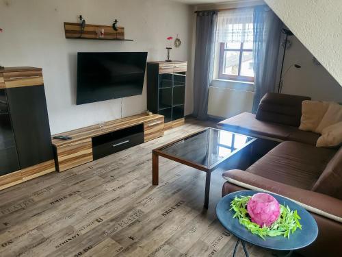 uma sala de estar com um sofá e uma mesa em FeWo im Gasthof Forsthaus em Marktredwitz