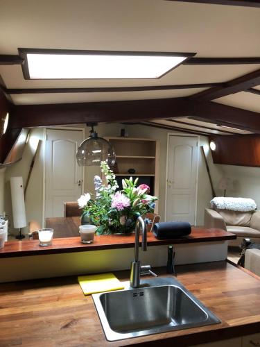 a kitchen with a sink and flowers on a counter at Klipper Johanna in Monnickendam