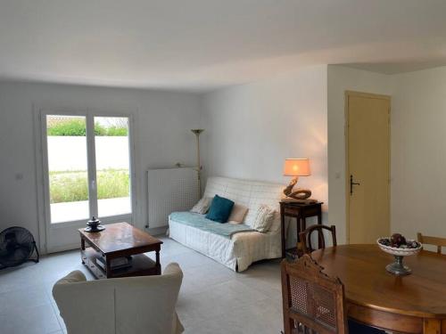 un salon avec un canapé et une table dans l'établissement Maison agréable à La Teste-de-Buch, à La Teste-de-Buch