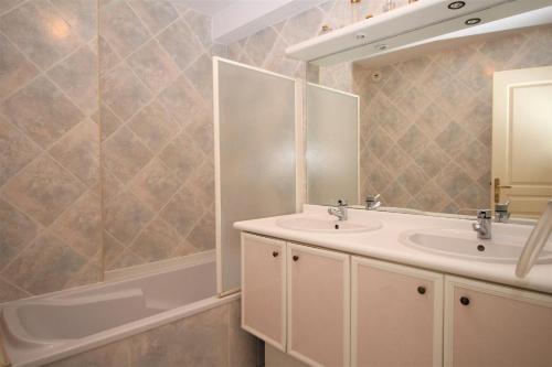 une salle de bain avec un lavabo, un miroir et une baignoire dans l'établissement Appartement 6 personnes VUE MER, à Canet