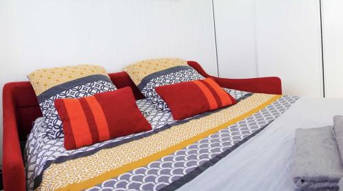 - un lit avec des oreillers colorés dans l'établissement Chez Jo, au Barcarès
