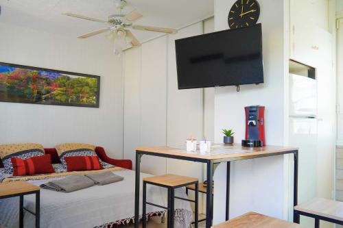 un salon avec une table et une télévision au mur dans l'établissement Chez Jo, au Barcarès