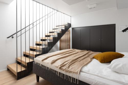 a bedroom with a bed and a staircase at Noli Otaniemi in Espoo
