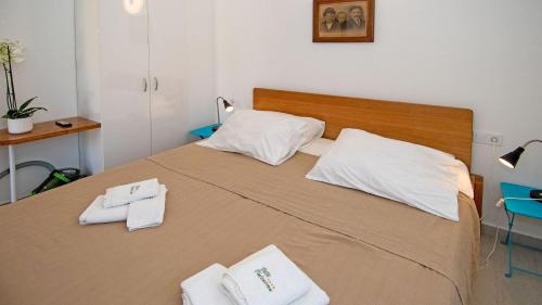 a bedroom with a large bed with towels on it at Holiday house Valencan 2 in Mednjan