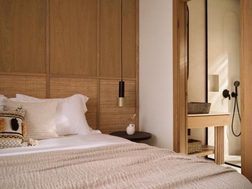 a bedroom with a bed with a wooden headboard at Verdante Villas in Agios Nikolaos