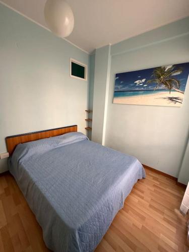 een slaapkamer met een bed en een foto van een strand bij Appartamento a 2 passi dal mare in Alba Adriatica