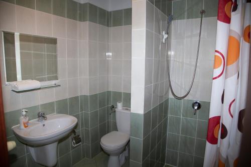 a bathroom with a toilet and a sink and a shower at Motel Paradise in Torzym