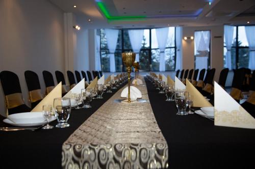 a long table in a room with glasses and chairs at Motel Paradise in Torzym