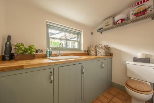 a bathroom with a sink and a toilet at Tern Cottage in Burnham Market