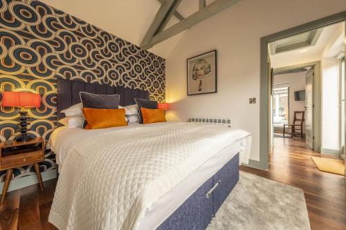 a bedroom with a large bed with orange pillows at Tern Cottage in Burnham Market