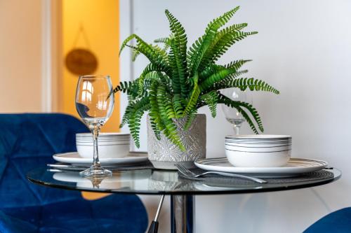a glass table with a plant and a wine glass at City Skyline View Studio Apartment - Birmingham Central in Birmingham