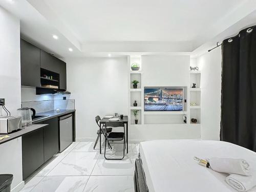 Cette chambre blanche dispose d'un lit et d'une cuisine. dans l'établissement Cosy Appartement, Part Dieu André Philipe, à Lyon