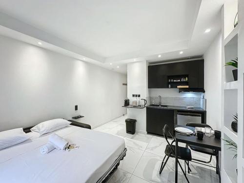 une chambre avec un lit et une table et une cuisine dans l'établissement Cosy Appartement, Part Dieu André Philipe, à Lyon
