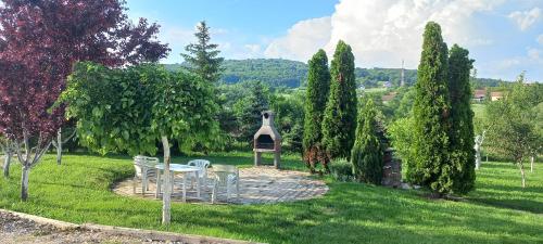 a garden with a table and chairs in the grass at FAKTOTUM in Donja Ralja