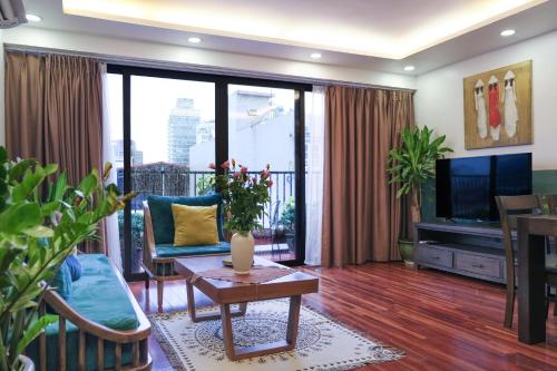 salon z kanapą i telewizorem w obiekcie Luxe Paradise residence 22 Nam Ngu street w mieście Hanoi
