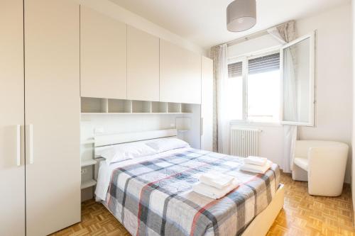 a white bedroom with a bed and a desk at Navile, Bologna By Short Holidays in Bologna