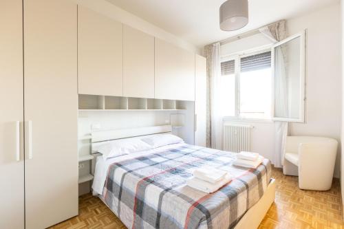 Un dormitorio blanco con una cama y un escritorio. en Navile, Bologna By Short Holidays, en Bolonia