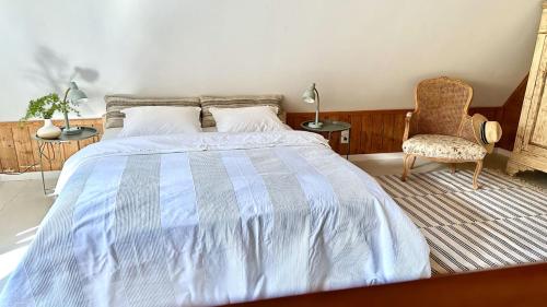 a bedroom with a large bed and a chair at Lustro Wody in Osiek