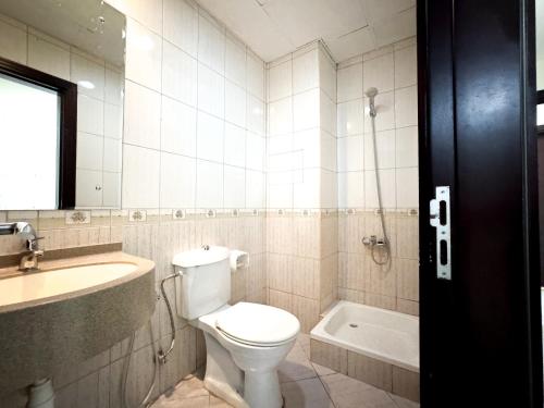 een badkamer met een toilet, een wastafel en een bad bij Nahda Star Residence - Home Stay in Dubai