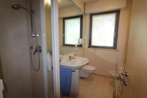 a bathroom with a sink and a toilet and a shower at Verdemare Pineta in Lignano Sabbiadoro