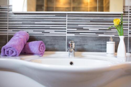 umywalkę w łazience z fioletowym ręcznikiem w obiekcie RELAXING HOME LUCE w mieście Čilipi